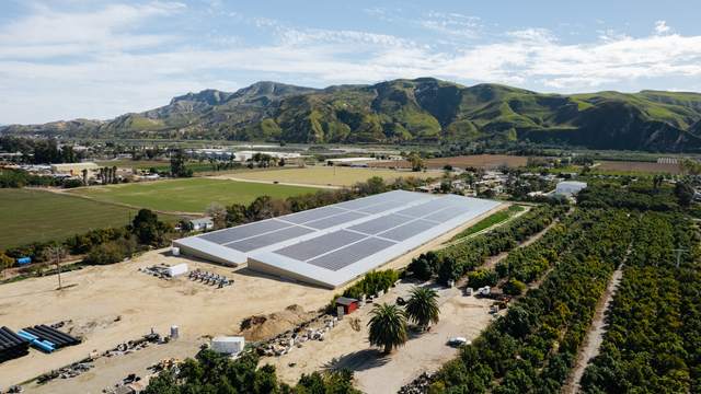 Covered reservoir with irrigation pipe stacks in the yard below