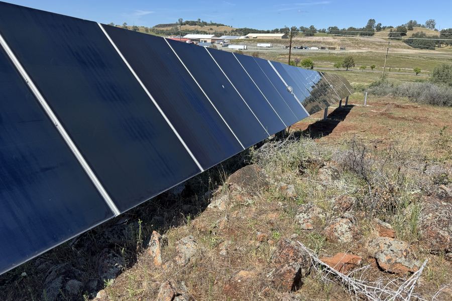 Solar rows following a hillside with the valley floor beyond