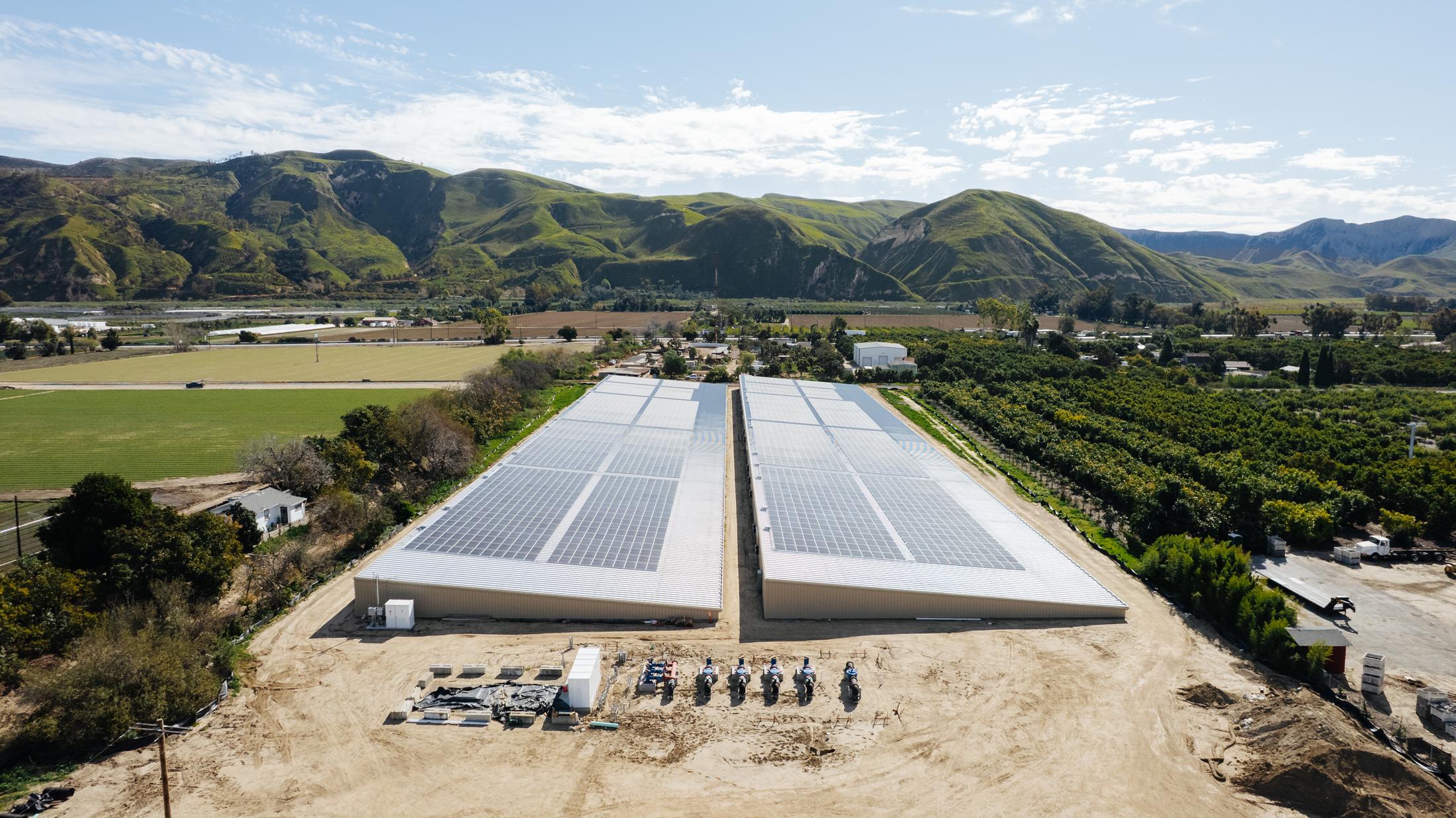 Aerial view of solar arrays on two covered reservoirs in the Santa Clara River Valley, green hills behind