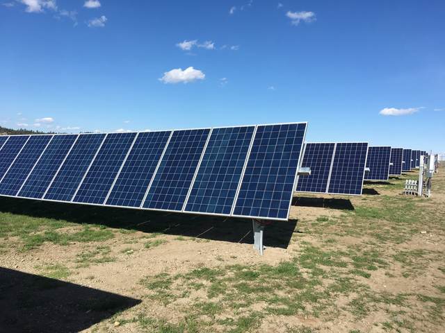 Ground view of tracker-mounted panels in a mountain meadow